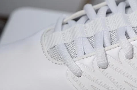 Macro Close-up of White Sneaker Laces and Eyelets 库存照片
