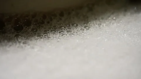 Macro close-up of white soap foam with dense bubbles forming a soft frothy layer Stock Footage 317591061