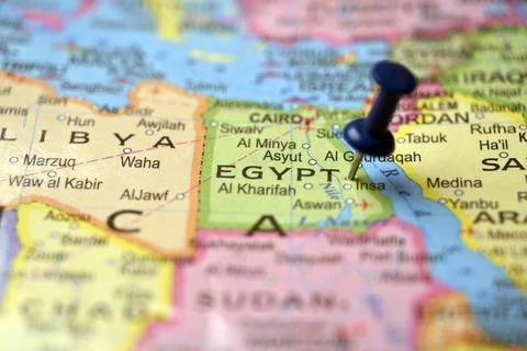 Macro Closeup of Blue Push Pin Pointing Egypt on Vintage Paper World Atlas 스톡 사진
