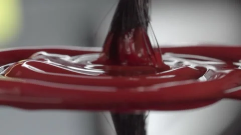 Macro Closeup of Brush Stirring Red Acrylic Paint Creating Smooth Swirling Stock Footage 340799963