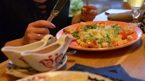 Macro closeup of caesar salad on plate with red tongs, parmesan cheese, dressing Stock Footage 97823300