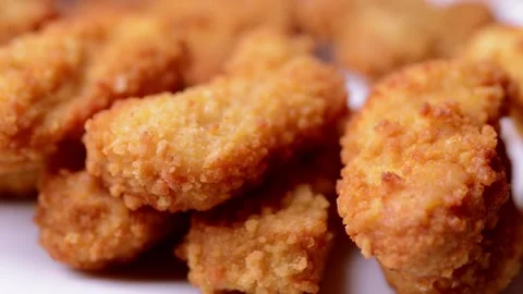 Macro closeup of chicken nuggets snacks rotating spinning on a dish Vídeos de archivo 152647425