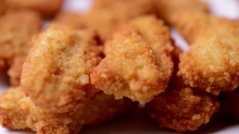 Macro closeup of chicken nuggets snacks rotating spinning on a dish 動画素材 152647475