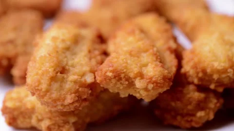 Macro closeup of chicken nuggets snacks rotating spinning on a dish Vídeos de archivo 152647799