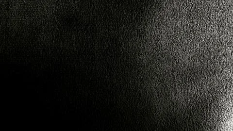 Macro closeup of dramatic black rough textured surface with deep shadow and s Stock Photos
