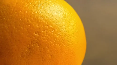 Macro closeup of fresh orange showing fruit skin texture as water squirts aga Stock Footage 61531074