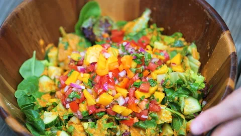 Macro closeup of fruit vegetable mango green salad in wooden bowl Stock Footage 145698984