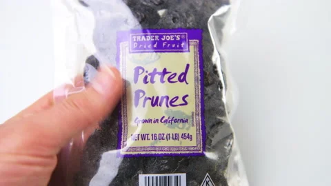 Macro closeup hand holding Trader Joe's dried fruit prunes package Stock Footage 194160502