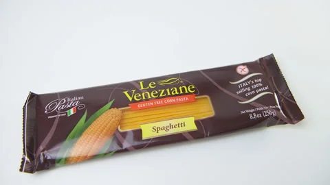 Macro closeup of hand placing yellow corn Italian spaghetti pasta on table Stock Footage 194154269