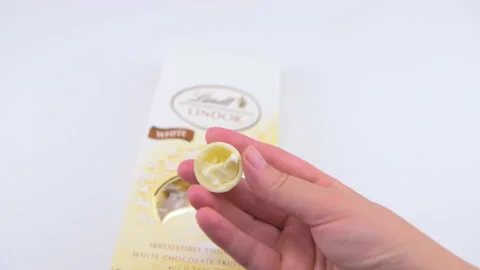 Macro closeup of hand taking one Lindt white chocolate truffles box Stock Footage 209699357