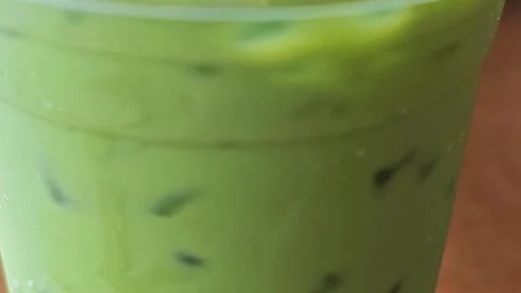 Macro Closeup of Iced Green Tea Matcha Latte in Plastic Cup. Stock Footage 340487599