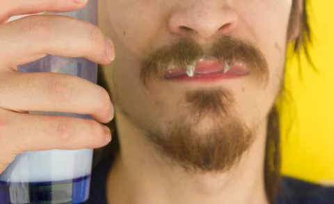 Macro closeup of lower half of man's face with thick white milk covering uppe Stock Photos