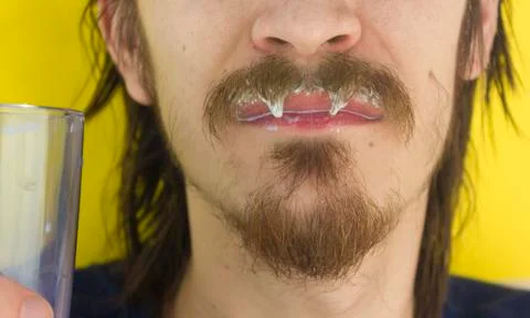Macro closeup of lower half of man's face with thick white milk covering uppe Stock Photos