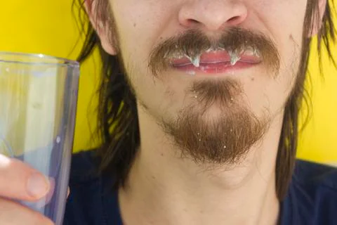 Macro closeup of lower half of man's face with thick white milk covering uppe Stock Photos