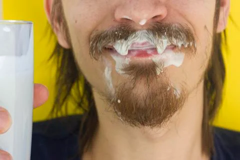 Macro closeup of lower half of man's face with thick white milk covering uppe Stock Photos