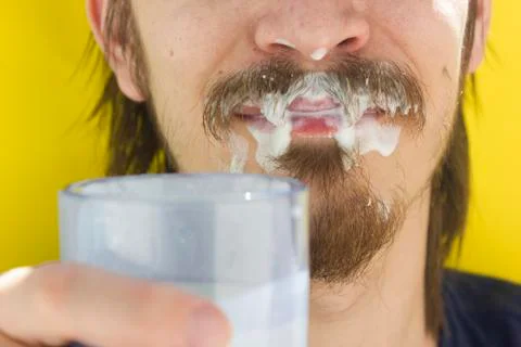 Macro closeup of lower half of man's face with thick white milk covering uppe Stock Photos