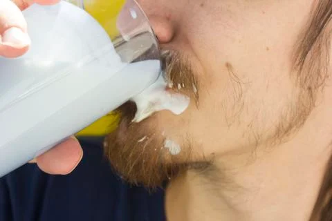 Macro closeup of lower half of man's face with thick white milk covering uppe Stock Photos
