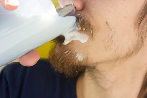 Macro closeup of lower half of man's face with thick white milk covering uppe Stock Photos
