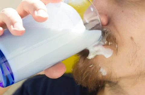 Macro closeup of lower half of man's face with thick white milk covering lip Stock Photos