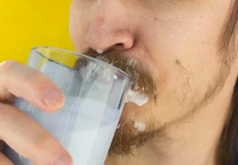Macro closeup of lower half of man's face with thick white milk covering lip Stock Photos