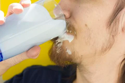 Macro closeup of lower half of man's face with thick white milk covering lip Stock Photos