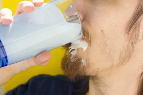 Macro closeup of lower half of man's face with thick white milk covering uppe Stock Photos