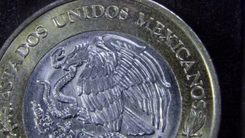 Macro closeup of a Mexican bimetallic coin showing the eagle and snake national Stock Footage 328224361