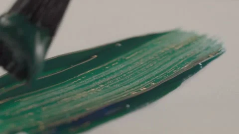 Macro Closeup of Paintbrush Spreading Green Acrylic Paint Across White Surface Stock Footage 340806730