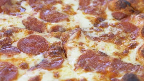 Macro closeup of pepperoni pizza reveals melted cheese texture and generous meat 스톡 동영상 335652838