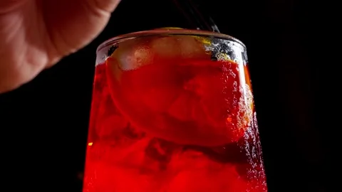 Macro Closeup of Red Cocktail with Citrus Garnish and Condensation Stock Footage 337862634