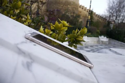 Macro closeup of smartphone, forgotten lying on marble at park Stock Photos