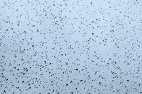 Macro closeup of sparkling rain dew drops on a window glass texture pattern a Stock Photos