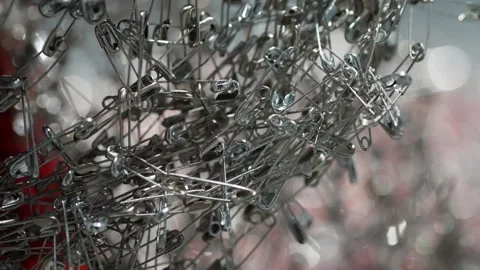 Macro closeup of tangled silver safety pins forming a dense metallic cluster Stock Footage 327530892