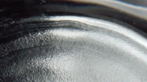 Macro Closeup of Water Drop Falling Onto Liquid Surface Creating Circular Stock Footage 340798986