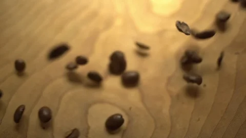 Macro of coffee beans being poured into a wooden bowl Stock Footage 87857503