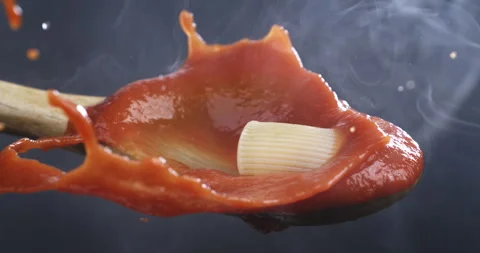 Macro of cooked italian pasta falling in steamy tomato sauce in wooden spoon Stock Footage 268880648