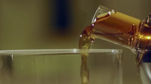 Macro crop shot of someone pouring black tea from glass teapot slow motion Stock Footage 144163448