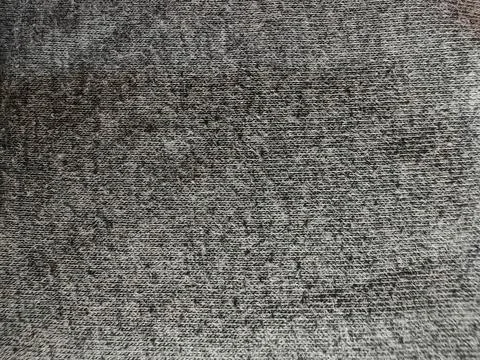 Macro of dark gray marled knit fabric texture. Distressed charcoal textile b Stock Photos