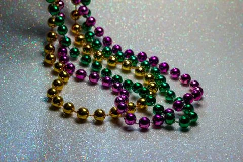 Macro defocused Mardi Gras beads on white glitter background Stock Photos