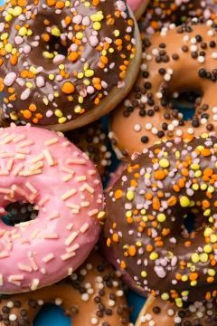 Macro delicious donuts colored glaze in sunlight Stock Photos
