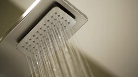 Macro Detail of Rectangular Shower Head Spraying Water - Slow Pan Left - UHD 4K Stock Footage 344082744