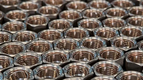 Macro detail of shiny brass nuts organized in tight rows. Precision engineering Stock Footage 329311588