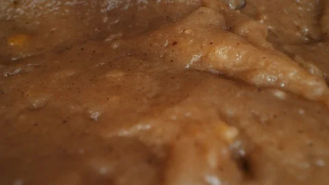 Macro dolly back across cookie dough as chocolate chips drop into batter Video stock 129290916