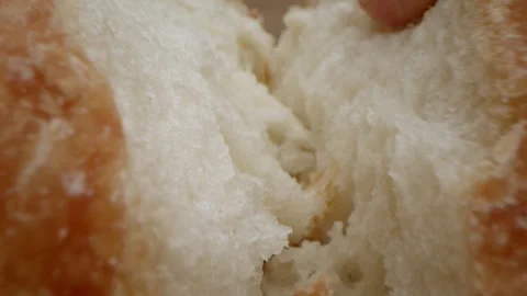 Macro dolly in breaking fresh baked bread. Slow motion. Freshly baked sourdough Stock Footage 256112113