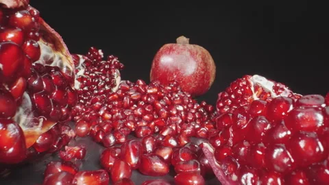 Macro dolly shot of fresh pomegranate and seeds on black table, probe dolly s Stock Footage 330121834