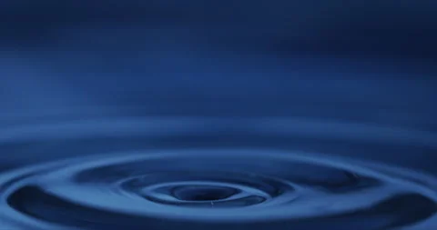 Macro of dripping drop of water falls into liquid fluid surface with splashes Video stock 269383715