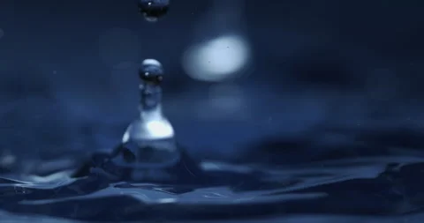 Macro of dripping drop of water falls into liquid fluid surface with splashes Video stock 269383780