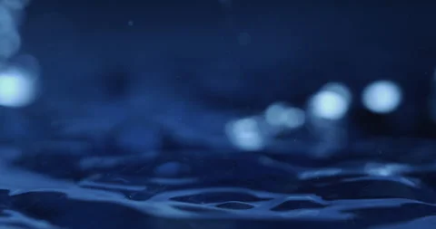 Macro of dripping drop of water falls into liquid fluid surface with splashes Video stock 269383822