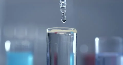 Macro of dropper drops liquid into test tubes in scientific laboratory Stock Footage 268980629