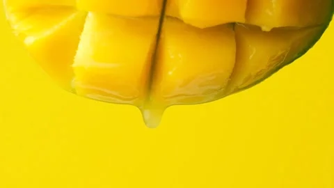 Macro drops of fresh mango juice dripping from fresh fruit slow motion Stock Footage 329414106